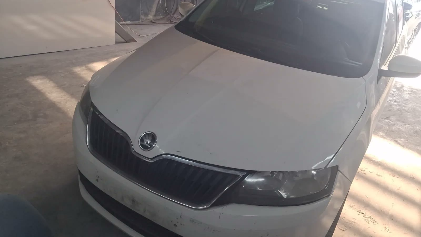 Beyaz Škoda aracın kaput onarımı sonrasındaki sol ön görünümü