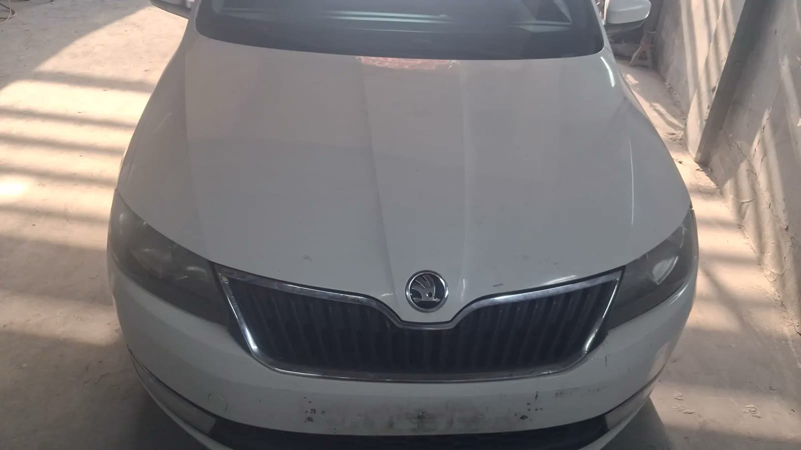 Beyaz Škoda aracın kaput onarımı sonrasındaki ön görünümü